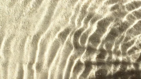 Slow motion water surface ripples and splash with palm tree leaf shadow on sand Stock Footage 197396575