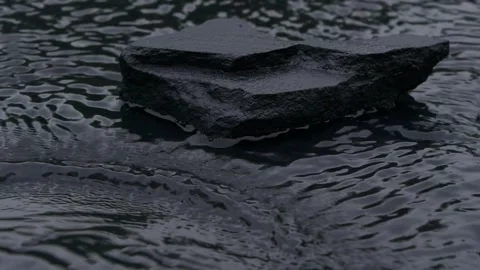 Slow motion water surface texture splashes, waves and ripples with black stone Video stock 255758860
