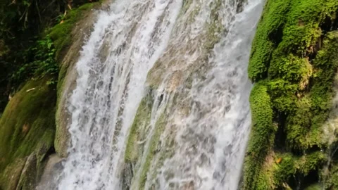 Slow motion of a waterfall flowing with mossy cliffs Stock Footage 321861251