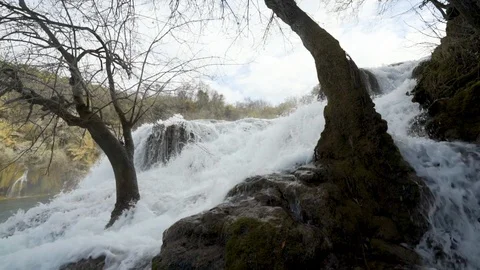 Slow motion - waterfall flowing through trees on cliffs Stock Footage 103115890