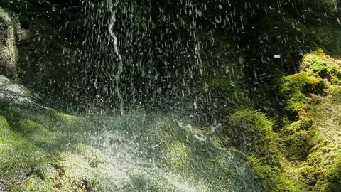 SLOW motion, waterfall in mountains. Closeup water drops falls splashing on moss Stock Footage 92688081