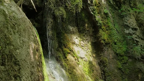 SLOW motion, waterfall in mountains. Closeup water drops falls splashing on moss Stock Footage 92700751