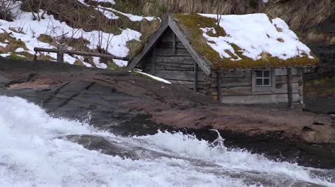 Slow motion waterfall past mill house. Looping Stock Footage