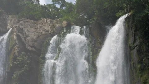Slow Motion Waterfall Pours over Rocks in Jungle Stockbeeldmateriaal 117651321