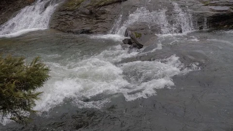 Slow motion of waterfall showing current then pan up to beautiful falls Stock Footage 121697672