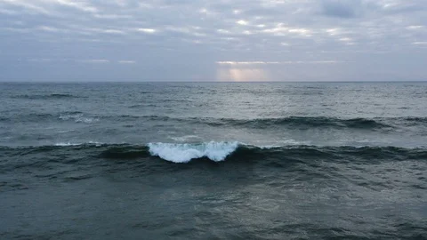 Slow-motion wave breaks as sun sets over vast peaceful ocean Stock Footage 112703331