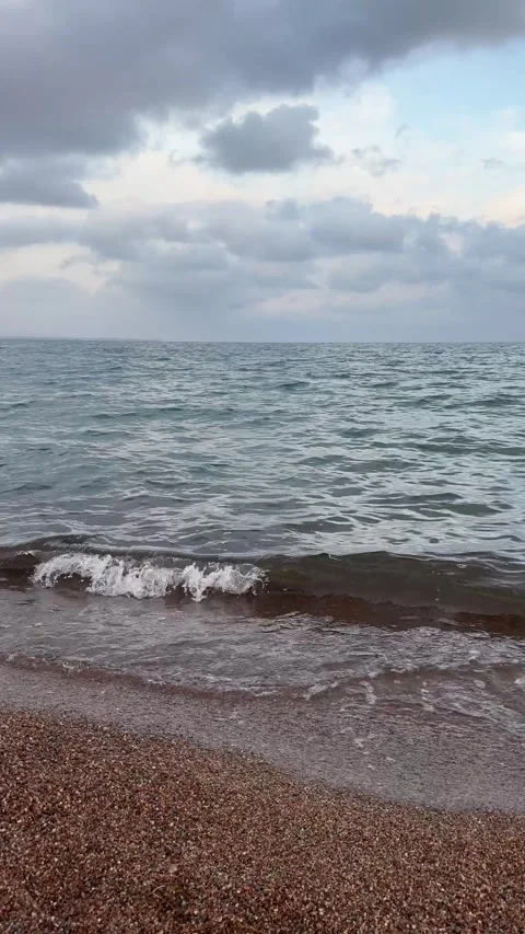Slow motion of wave on the coast in cloudy weather, clouds in the gloomy sky Stock Footage 297602799