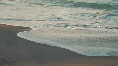 Slow Motion Wave Foam Washing Over Black Sand Beach Leaving Wet Sand Texture Stock Footage 334583162
