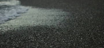 Slow Motion Wave Over Black Sand Stockbeeldmateriaal 85821884