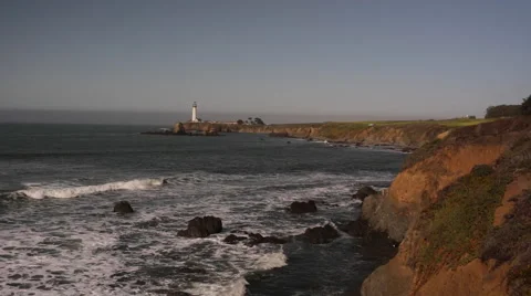 Slow motion waves against the shore with lighthouse in the background Stock Footage 46940470