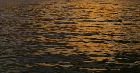 Slow motion waves and reflections at sunset. Sunlight sparkles over ocean waves. Stock Footage 233406192
