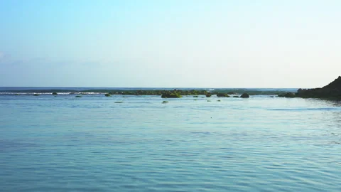 Slow motion waves are broken by green rock in ocean Stock Footage 287715353