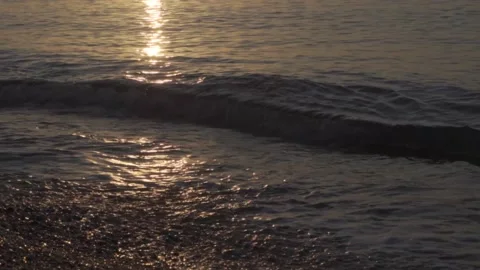 In slow motion waves are rolling in during the sunrise from June in Barcelona Stock Footage