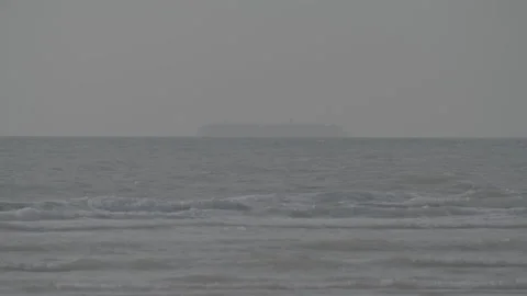 Slow motion waves with big container ship in the background Stock Footage 169652667