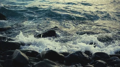 Slow motion waves break on rocks on the shore Stock Footage 81786769