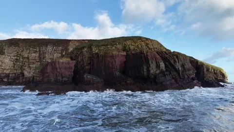 Slow Motion Waves Breaking Along Rocky Coastal Cliffs in 4K Stock Footage 332944768