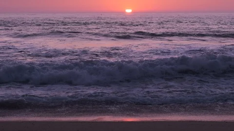 Slow motion waves breaking on beach at sunset, with sun on horizon. Stock Footage 115920468