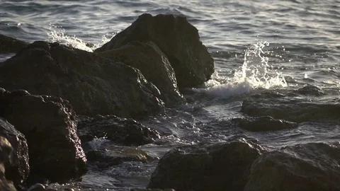 Slow Motion Waves Breaking Over Rocks at Sunset Stock Footage 78211230
