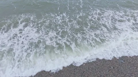 Slow motion of waves breaking on to the pebble beach Stock Footage 313526431