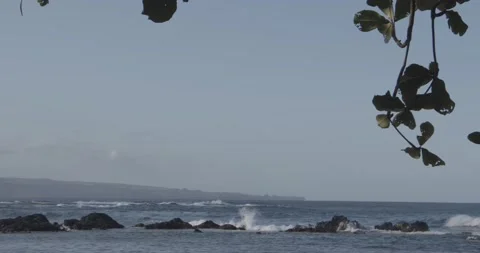 Slow motion waves crash against volcanic rocks in a tropical sea Stock Footage 137664917