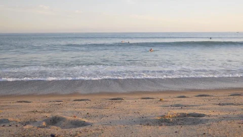 Slow Motion Waves Crash on Beach with Sufers in Water Video stock 116688806