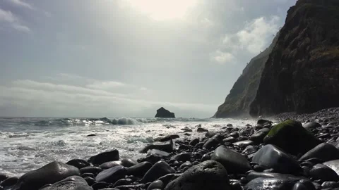 Slow Motion Waves Crash on Rocky Shoreline of Madeira Island Under Dramatic Sky 스톡 동영상 345019910
