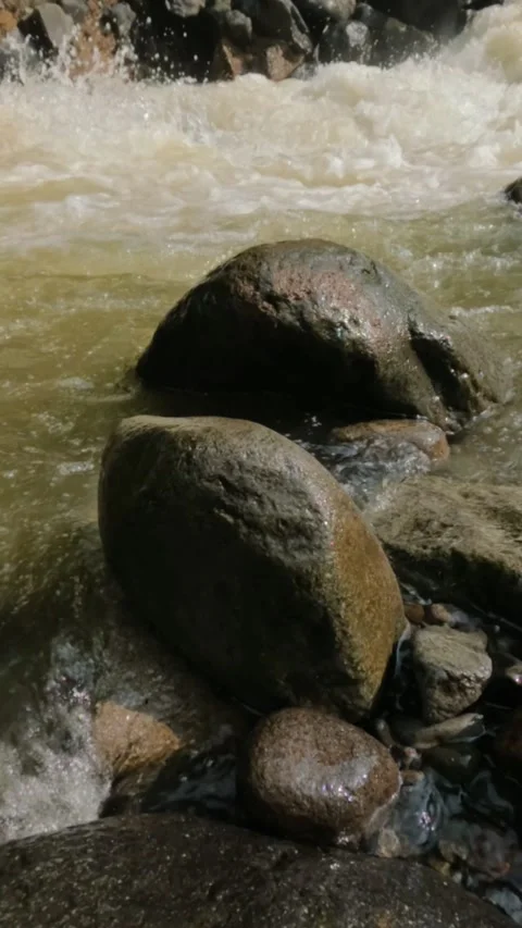 Slow motion of waves crashing against rocks on the river bank Stock Footage 319921740