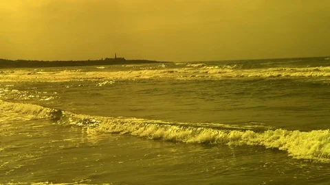 Slow motion of waves crashing on beach w/ abandoned factory in background. Video stock 113642067