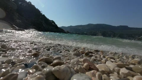 Slow motion waves crashing on beach with mountain view Stock Footage 313483313
