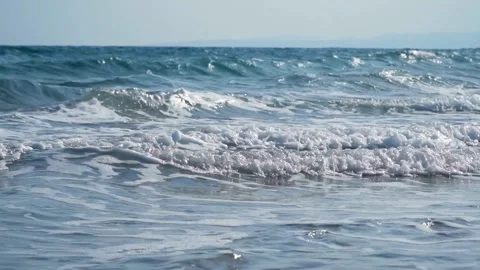Slow motion waves crashing on beach with white foam Video stock 333830620