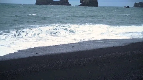 Slow motion waves crashing into black sand beach Видео 72331766