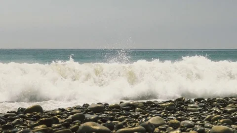 Slow motion waves crashing into pebbles on beach Stock Footage 78661588