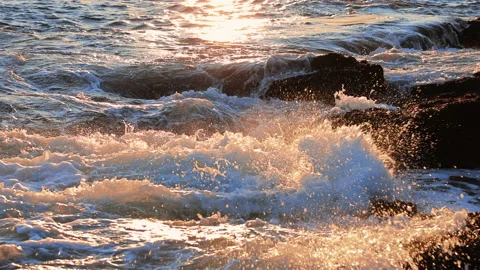 Slow Motion of Waves Crashing on Rocks at Sunset Stock Footage 168325703
