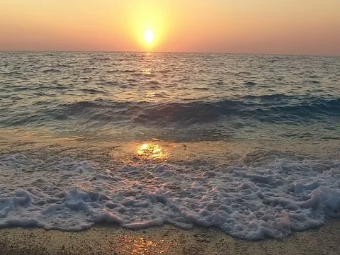 Slow motion of waves crashing on the sandy beach at vivid sunset, slow motion Stock Footage 80064992