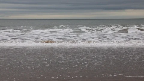 Slow motion waves crashing onto sandy beach Stock Footage 88584436