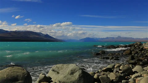 Slow motion waves crashing on the shore of blue lake in New Zealand Stock Footage 34340047