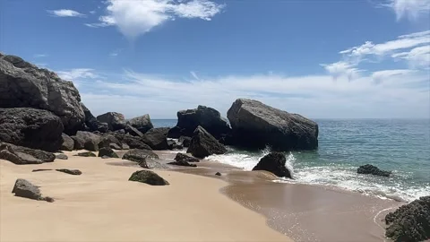 Slow motion waves crashing into small rock Stock Footage 243194864