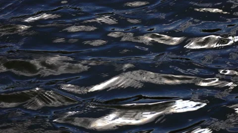 Slow motion of waves on dark water surface with play of flecks close up Stock Footage 66519760