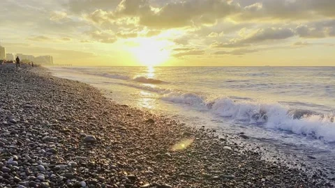 Slow motion of the waves during sunset. Many rocks on the beach coast in Batumi Stock Footage 229923108