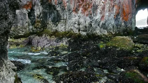 Slow-motion of waves entering a cave on Chiloe island in Chile Stock Footage 12454286