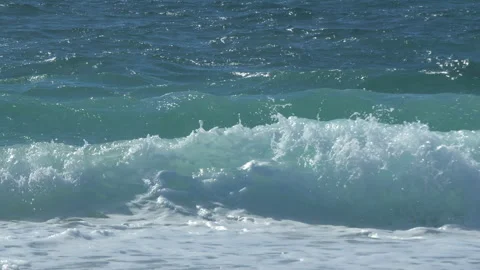 Slow motion waves forming and breaking on the shore of a beach in summer. Stock Footage 273657432
