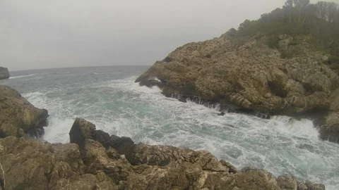 Slow motion waves hitting the cliff rocks Stock Footage 107281129