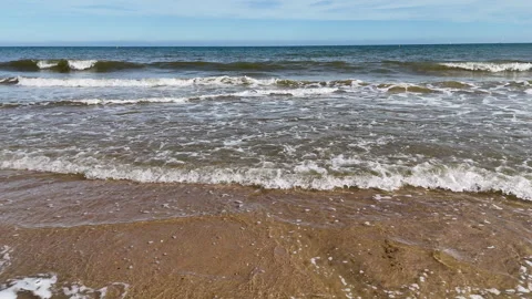 Slow motion waves lapping a sandy beach Stock Footage 310697294