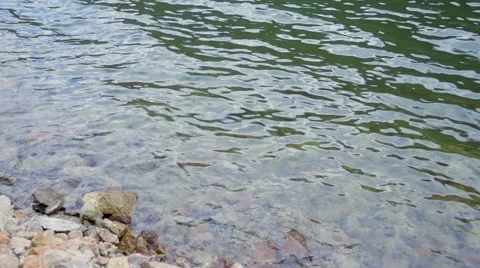 Slow Motion Waves Ripple and Break On a Rocky Shoreline Stock Footage 66524986