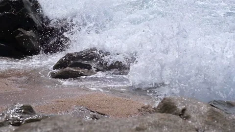 Slow motion waves splashing against rocks on the beach. Close up Stock Footage 151874841