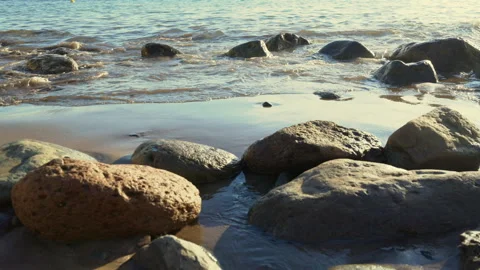 Slow motion. Waves Splashing Over Rocks On Sandy Beach Shoreline. Video stock 327712997