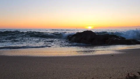 Slow motion waves splashing on sandy beach at sunset Stock Footage 115756490