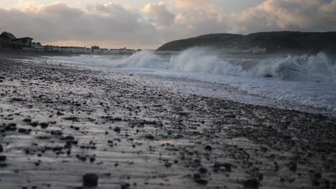 Slow motion waves on stoney beach at magic hour, LLandudno. Video stock 150289454