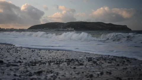 Slow motion waves on stoney beach at magic hour, LLandudno. Video stock 150289631