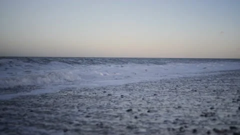 Slow motion waves on stoney beach at magic hour. Video stock 150289740